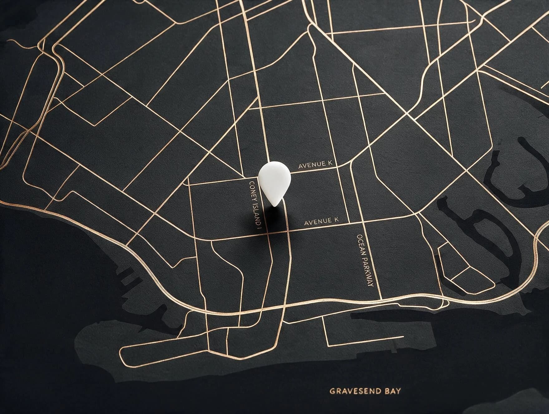 Stylized black-and-gold map of the Brooklyn neighborhood around 1122-A Coney Island Ave — Coney Island Avenue, Ocean Parkway and Gravesend Bay — marked with a cream location pin