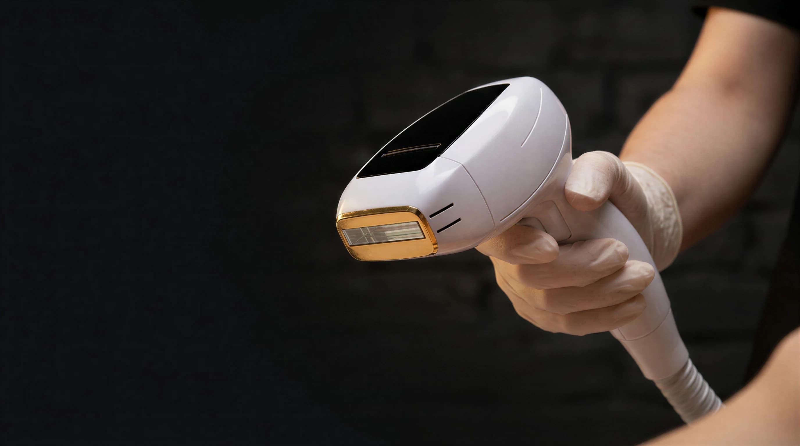 A gloved hand holding the DiolazeXL laser handpiece against a dark backdrop