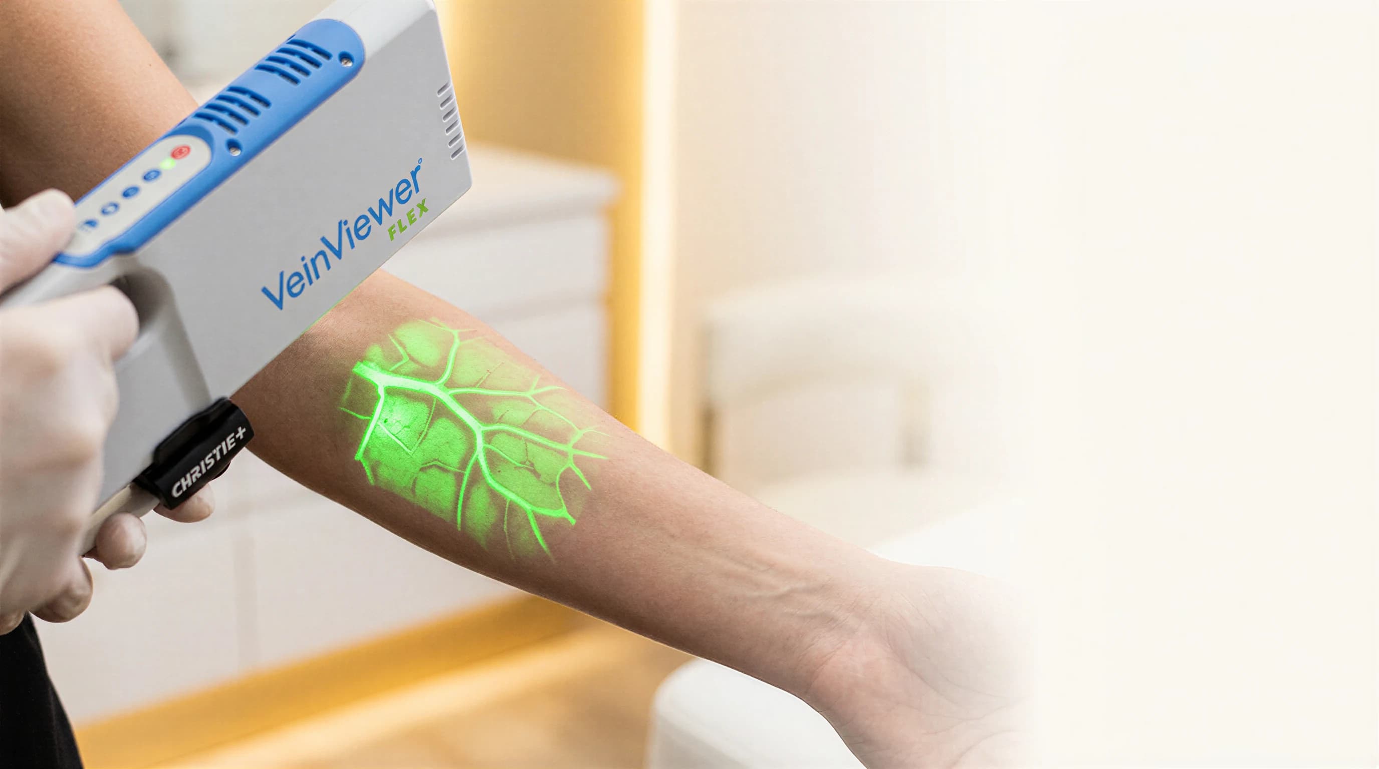 The VeinViewer Flex projecting a green vein map onto a patient's forearm